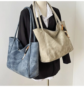 Detail of vintage textured PU leather tote bag with wooden bead charm and long straps