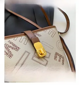 Détail macro du sac seau beige avec lettres léopard et fermoir rotatif doré élégant