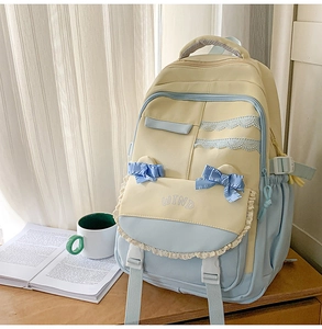 Detail of color-block backpack with lace trim, satin bow, and WIND embroidery detail