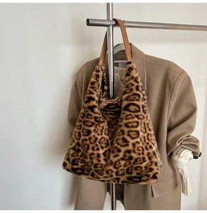 Detail of leopard print faux fur tote bag hanging next to a khaki suit jacket