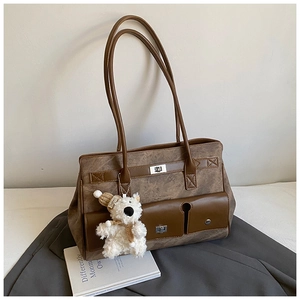 Detailed texture of brown PU leather tote with a cute plush bear charm on its handle
