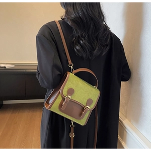 Detail of vintage olive green matte backpack with brown leather trim and retro buckles
