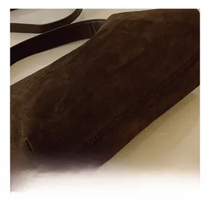 Detailed close-up of dark brown suede texture with side stitching on the retro pillow bag