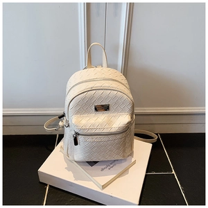 Dettaglio dello zaino in pelle intrecciata bianco sporco con tasca anteriore e zip in metallo