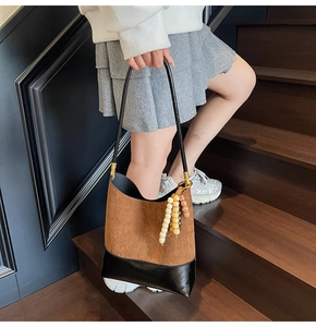 Détail du sac cabas en suédine avec lanières en cuir et breloques en perles de bois