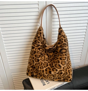 Detailed texture of leopard print faux fur tote bag on books with brown straps