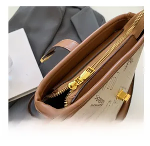 Vue détaillée du dessus montrant la fermeture dorée et le motif logo sur le sac