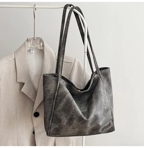 Macro detail of minimalist grey tote bag with vintage texture and soft shoulder straps