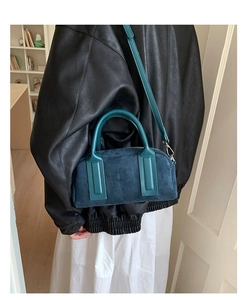 Detail of navy blue suede bowling bag featuring silver hardware and structured handles