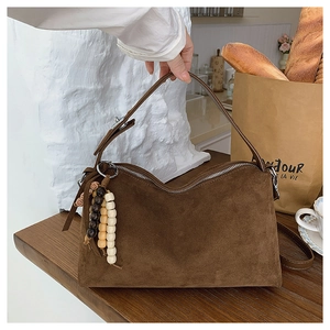 Retro dark brown suede underarm bag on a wooden table with French vintage accessories