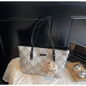 Dettaglio borsa shopper a scacchi con pois, manici in pelle e ciondolo orsetto morbido