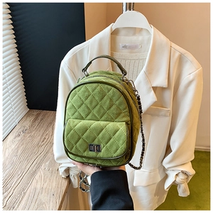 Detail of green quilted suede mini backpack with gold chain strap and turn-lock closure