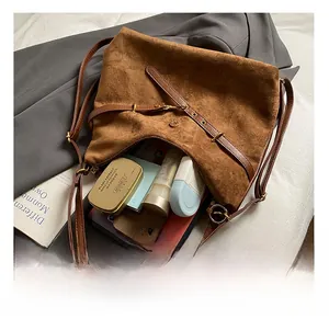 Capacité intérieure du grand sac bandoulière en daim marron avec objets personnels