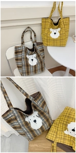 Detail of wool plaid tote bag featuring a cute white schnauzer embroidered patch