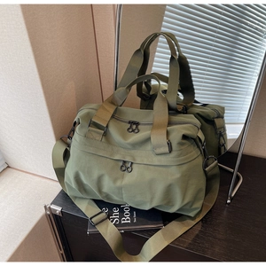 Macro shot of olive green canvas tote with heavy-duty zipper and adjustable strap