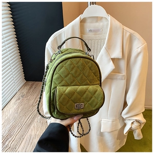 Detail of green quilted suede backpack with metal twist lock and chain strap