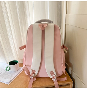 Detailed back view of pink backpack featuring white padded straps and breathable mesh padding
