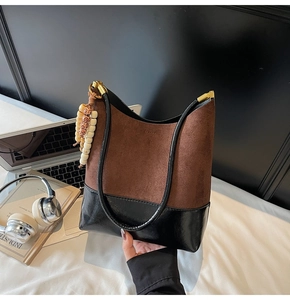 Détail du sac hobo avec texture mate contrastée, boucle dorée et breloque en perles