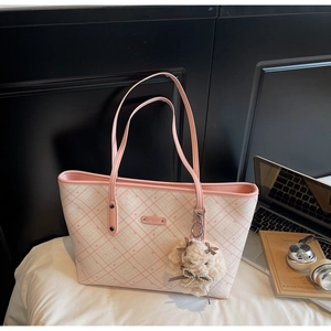 Dettaglio borsa shopper a quadri rosa con placca in metallo e charm a forma di cagnolino