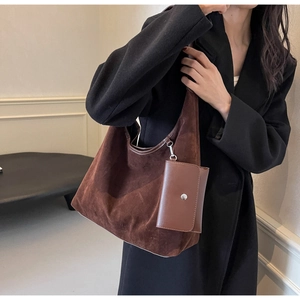 Detailed close-up of a dark brown suede tote bag featuring a matching detachable coin purse