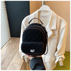 Detailed view of the black quilted mini backpack with chain strap and metal turn-lock