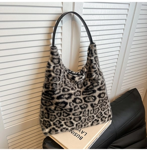 Detail of soft leopard print faux fur tote bag with black leather shoulder strap