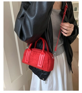 Chic red suede bowling bag detail worn with a black leather jacket and white dress