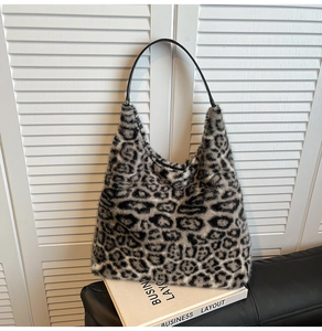 Close-up of soft leopard print faux fur tote bag with black shoulder straps and plush texture