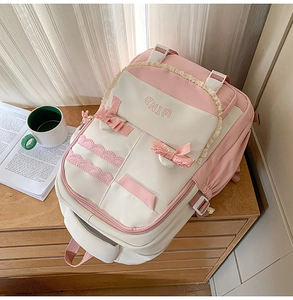 Detail of pink and beige school backpack with lace edges, ribbon bow and WIND embroidery