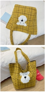 Close-up of yellow plaid tote bag with cute white dog embroidery on wool fabric