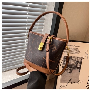 Vue détaillée d'un sac seau marron foncé avec motifs vintage et fermoir doré chic
