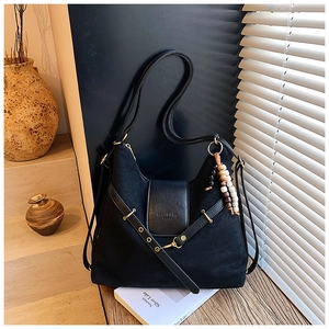 Détail du sac hobo noir mat avec perles en bois exotiques et logo embossé chic