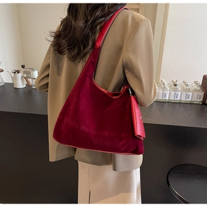 Detail view of large burgundy suede tote bag with a small matching coin purse attachment