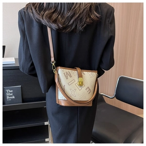 Vue arrière d'un mannequin portant un sac seau crème avec bordure en cuir marron et boucle