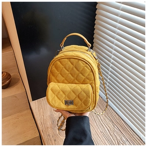Close-up of ginger quilted mini backpack with suede texture and metal chain straps