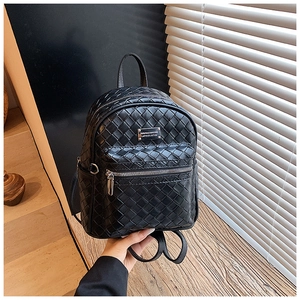 Dettaglio dello zaino in pelle intrecciata nera con placca logo in metallo e tasca zip