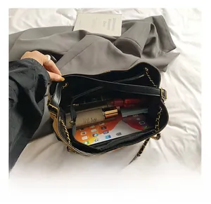 Vista interna della grande borsa tote che mostra ampi scomparti con cosmetici e telefono