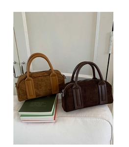 Detail of suede boston bags in caramel brown and dark coffee with matte smooth handles