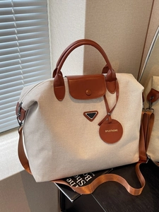 Large capacity canvas travel tote bag with leather handles and metallic logo detail