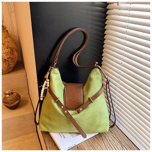 Détail du sac à main en daim vert avec bordure en cuir et perles décoratives en bois