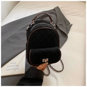 Close-up of quilted velvet mini backpack with chain strap and silver twist-lock detail