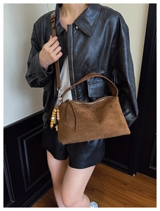 Vintage brown suede crossbody bag with wooden bead charm and adjustable leather strap