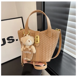 Dettaglio della borsa a secchiello intrecciata marrone con chiusura e orsetto peluche