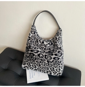Close-up of leopard print faux fur texture and black leather strap on tote bag