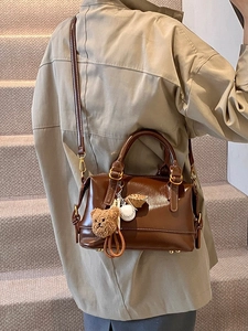Vintage dark brown Boston bag with teddy bear charm and adjustable shoulder strap