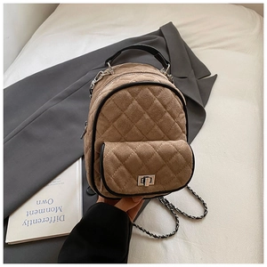 Detail of a brown quilted mini backpack with metal twist lock and chain strap texture