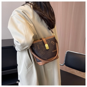 Vue détaillée d'un sac seau vintage marron foncé avec monogramme et boucle en métal doré