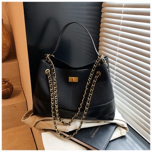 Détail du sac seau en cuir matelassé avec chaîne dorée et fermoir rotatif élégant
