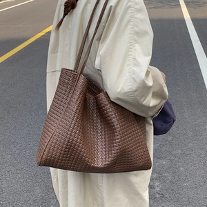 Vue détaillée du sac cabas tressé marron foncé avec une texture de cuir de haute qualité