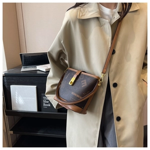 Détail du sac seau vintage à monogramme avec boucle magnétique dorée et bandoulière